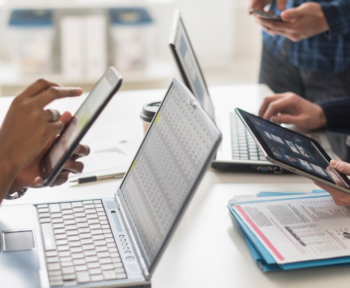 Empresários a utilizar tecnologia no escritório.