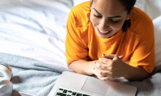 Mulher a sorrir a olhar para o computador portátil